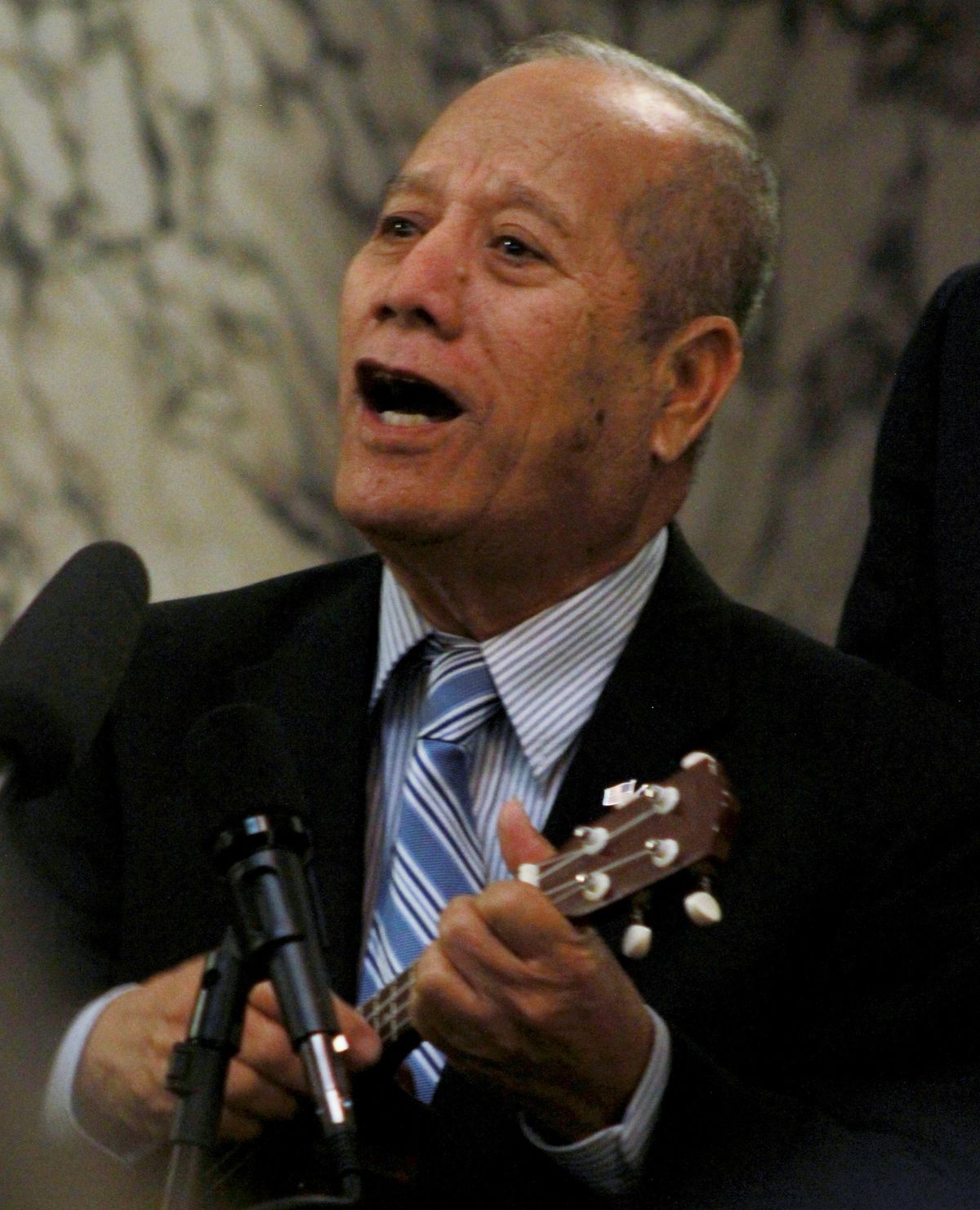 Saimon Milne, a Marshallese elder from Spokane, accompanies other Pacific Islanders as they sing “There Is No Better Time Than Now” during the signing ceremony at the Capitol on Thursday, March 22, 2018. (Rachel Sun / For The Spokesman-Review)