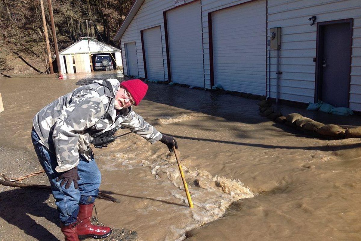 Stevens County Fire District 2 Chief Rick Anderson measures the depth of water outside his Hunters, Wash., fire station. (Courtesy photo)