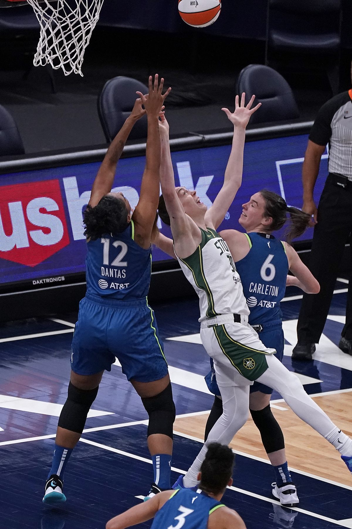Minnesota Lynx forwards Damiris Dantas (12) and Bridget Carleton (6) work against Seattle Storm forward Breanna Stewart (30) for a rebound during the first quarter of a WNBA basketball game Thursday, May 20, 2021, in Minneapolis. (Associated Press)