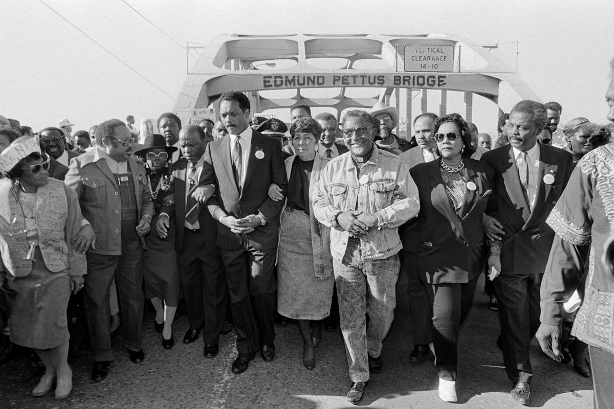 The Rev. Jesse Jackson, center left, and civil rights figures lead a march across the Edmund Pettus Bridge in Selma, Ala., on the 25th anniversary of “Bloody Sunday,” on March 6, 1990. Jackson, whose impassioned oratory and populist vision of a “rainbow coalition” of the poor and forgotten made him the nation’s most influential Black figure in the years between the crusades of the Rev. Dr. Martin Luther King Jr. and the election of Barack Obama, died on Feb. 17.  (Michelle V. Agins/The New York Times)