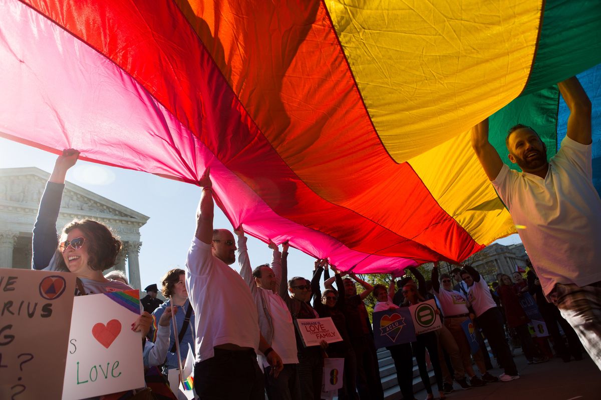 Same-sex marriage supporters hold up a giant flag in front of the Supreme Court in Washington, D.C., on April 28, 2015, when the court heart oral arguments in Obergefell v. Hodges, on whether the 14th Amendment requires that states grant and/or recognize same-sex marriages.  (Allison Shelley/For The Washington Post)