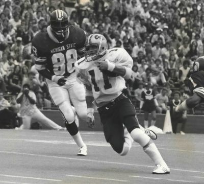 Former Washington State running back Dan Doornink (left) eludes Michigan State player Larry Bethea during a football game in 1977. Doornink is currently in a Yakima hospital battling COVID-19.  (Cowles Publishing Achives)