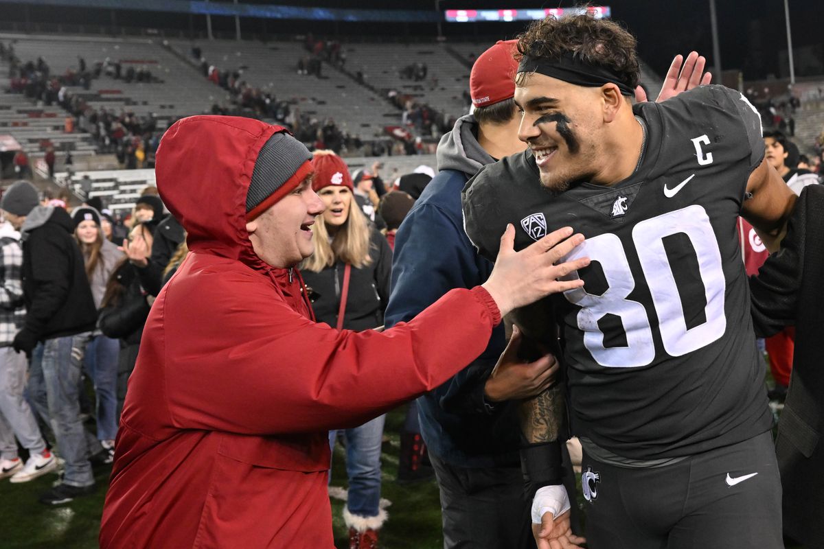 WSU fans rush the field and celebrate with Washington State Cougars defensive end Brennan Jackson (80) after WSU defeated Colorado during the second half of a college football game on Saturday, Nov. 18, 2023, at Gesa Field in Pullman, Wash. WSU won the game 56-14.  (Tyler Tjomsland/The Spokesman-Review)