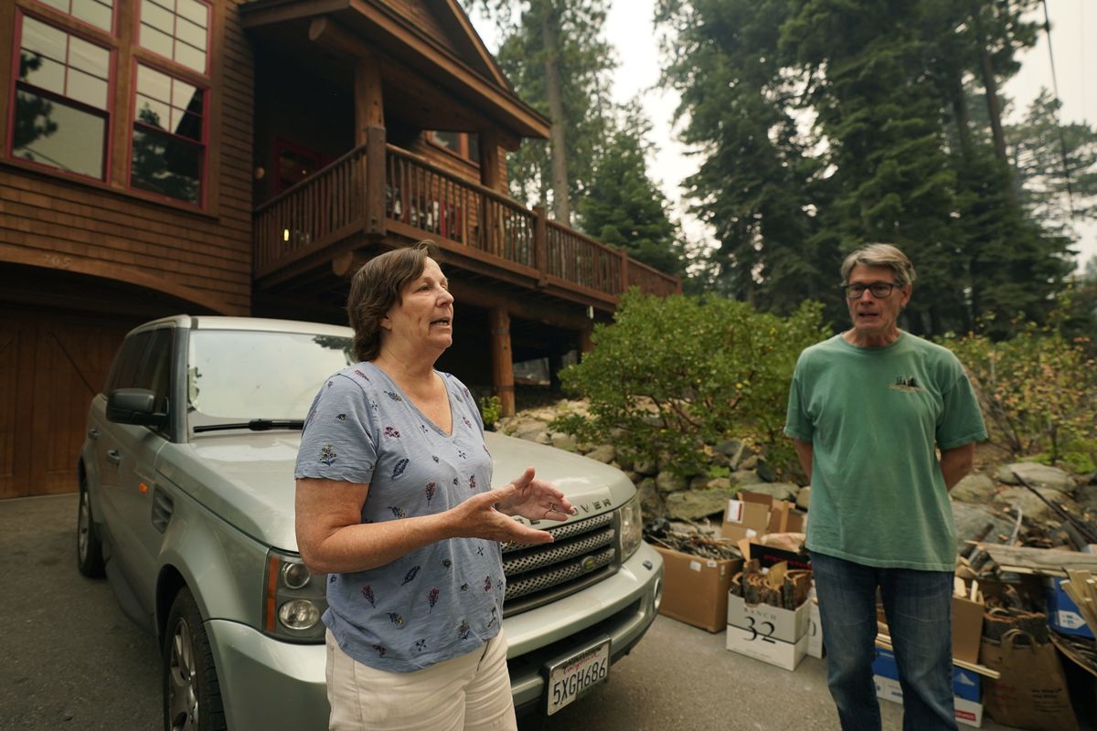 Diane Nelson and her husband Rick, discuss the approaching Caldor Fire that threatens their home on Fallen Leaf Lake near South Lake Tahoe, Calif., Tuesday, Aug. 24, 2021. The couple were planning to host their daughter
