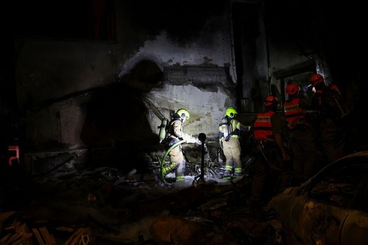 Firefighters work at the scene of a Hezbollah rocket attack on a residential building, amid escalation between Hezbollah and Israel, and amid the U.S.-Israeli conflict with Iran, in Nahariya, northern Israel, March 16, 2026.  (Shir Torem)
