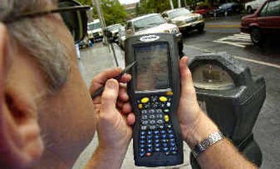 
Ed Basinger, city parking enforcement, checks out a new handheld wireless device that will allow patrols to check vehicles and issue parking citations.
 (Christopher Anderson/ / The Spokesman-Review)