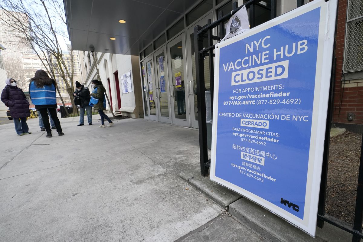 FILE - In this Jan. 21, 2021, file photo, people who had appointments to get COVID-19 vaccinations talk to New York City health care workers outside a closed vaccine hub in the Brooklyn borough of New York after they were told to come back in a week due to a shortage of vaccines. An increasing number of COVID-19 vaccination sites around the U.S. are canceling appointments because of vaccine shortages in a rollout so rife with confusion and unexplained bottlenecks.  (Kathy Willens)