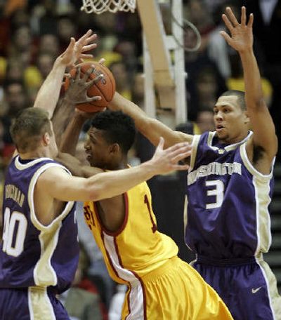 
Washington's Jon Brockman, left, and Brandon Roy, right, guard Southern California's Nick Young during the first half. 
 (Associated Press / The Spokesman-Review)