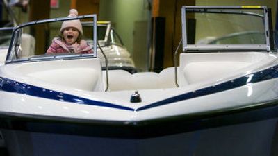 
Ashley Solt, 3, sits in the driver's seat of a new Crownline 180 BR for sale at the Spokane National Boat Show on Friday. 