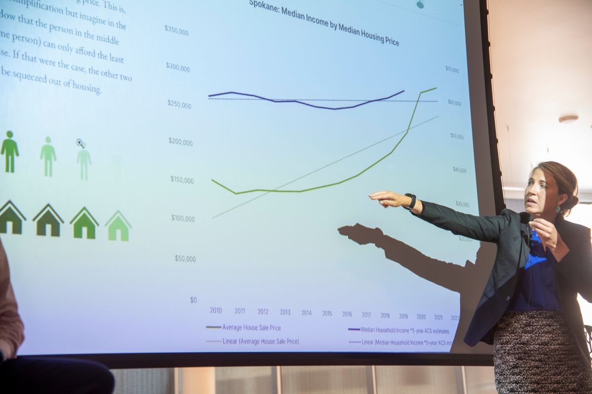 Shiloh Deitz, a data scientist working for the Spokane Public Library and the city of Spokane, points to a chart that shows income gains have not kept up with rising home prices in the Spokane area at a public meeting held Wednesday at the Spokane Central Library.  (Jesse Tinsley/THE SPOKESMAN-REVIEW)