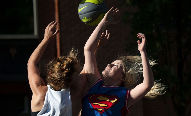 High Five Heroes teammate Ashli Woodin of Potlatch goes for a shot against a member of Back Woods Chicks during Hoopfest three-on-three basketball tournament in Spokane on Saturday, June 27, 2015. (Kathy Plonka)