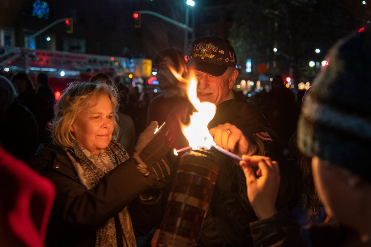 Marilyn and Robert Shay light their candles off a larger flame held by U.S. Rep. Cathy McMorris Rodgers (not shown) at the annual menorah lighting in Riverfront Park Sunday, Nov. 28, 2021. (Jesse Tinsley/THE SPOKESMAN-REVIEW)