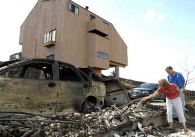 
John and Ellie Devitt look over their burned garage and cars as they return to their home of 30 years, Tuesday afternoon, after the Ford Fire swept through the area. Associated Press
 (Associated Press / The Spokesman-Review)