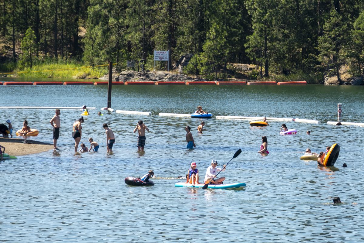 Swimmers flock to the swimming area at Q’Emiln Park beach on the Spokane River in Post Falls on Monday, where temperatures rose past 90 degrees in the midafternoon.  (JESSE TINSLEY)