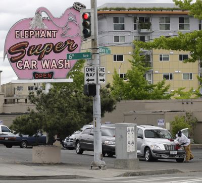 A worker dries a car at Seattle’s famous Elephant Car Wash near the Space Needle in 2009.  (Associated Press)