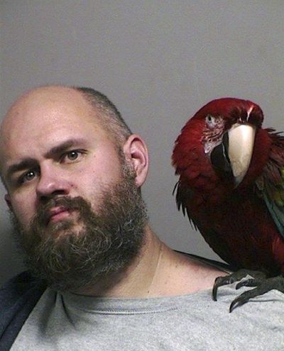 This booking photo provided Thursday by the Washington County Sheriff’s office taken in Hillsboro, Ore.,  shows Craig Buckner with his macaw, named “Bird.” (uncredited / Associated Press)