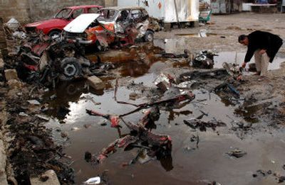 
An Iraqi sifts through debris after a car bomb exploded in Mahmoudiya, about 20 miles south of Baghdad, Iraq, on Sunday. The blast injured four people and set several cars on fire,  police said. 
 (Associated Press / The Spokesman-Review)