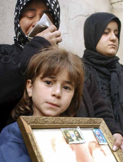 
Asmaa Hani holds a framed, bleached-out photo of her dead father, Hani Abdul-Karim, on Friday, as she stands with her mother, left, in the northern town of Mosul. Asmaa's father was one of 50 people killed when a suicide bomber blew himself up during a funeral being held in the courtyard of a Shiite mosque on Thursday.
 (Associated Press / The Spokesman-Review)