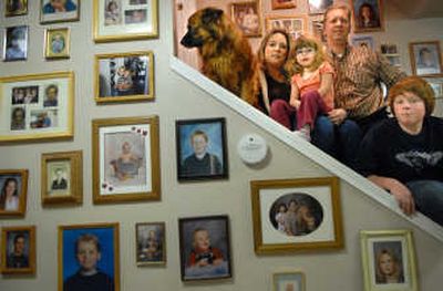 
Tricia Ross with her daughter, Bailee, 4, and fiancé Jon Weiland along with her son, Austin, 12, and the family dog Moohna survuived CO poisoning in their split-level Mead home. Now one of several CO detectors hangs with family portraits. 
 (Brian Plonka / The Spokesman-Review)