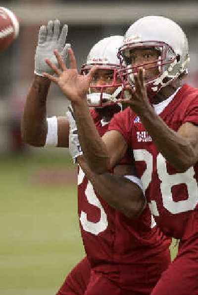 
Kerry Maddox, left, and Brian Williams fight for the ball during a passing defense drill at Rogers Field.
 (Brian Immel / The Spokesman-Review)