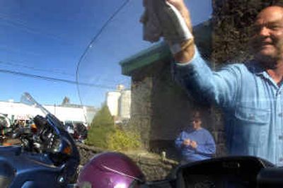 
Wally Youngman, of Lilac City Wings,  cleans the windshield of his Honda Goldwing on Sunday. 
 (Jed Conklin / The Spokesman-Review)