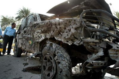 
An Iraqi policeman inspects a damaged armored SUV after the explosion of a car bomb near the Green Zone in Baghdad, Iraq, on Monday.
 (Associated Press / The Spokesman-Review)