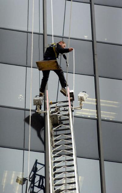 
A Spokane Fire Department aerial ladder is not quite tall enough to rescue this window washer at First and Post who became stranded Tuesday. After ropes and a wooden seat were lowered, he was able to let himself down.
 (Photos by Christopher Anderson/ / The Spokesman-Review)