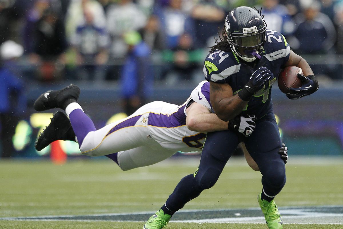 Seahawks running back Marshawn Lynch drags Minnesota’s Jared Allen with him during a rush in the second half. (Associated Press)