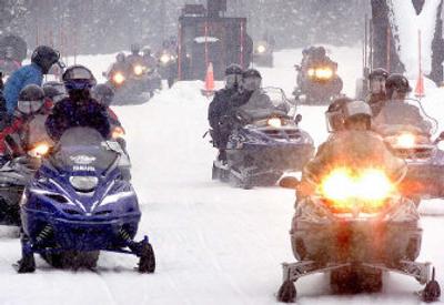
Snowmobilers pass through the West Yellowstone, Mont., entrance to Yellowstone National Park in 2002. A new draft plan would maintain current limits on snowmobiles in three national parks. 
 (File Associated Press / The Spokesman-Review)