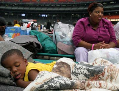 
Two-year-old Erroll Thomas sleeps peacefully as his mother Selika Thomas sits in the background Saturday at the Astrodome. 
 (Associated Press / The Spokesman-Review)