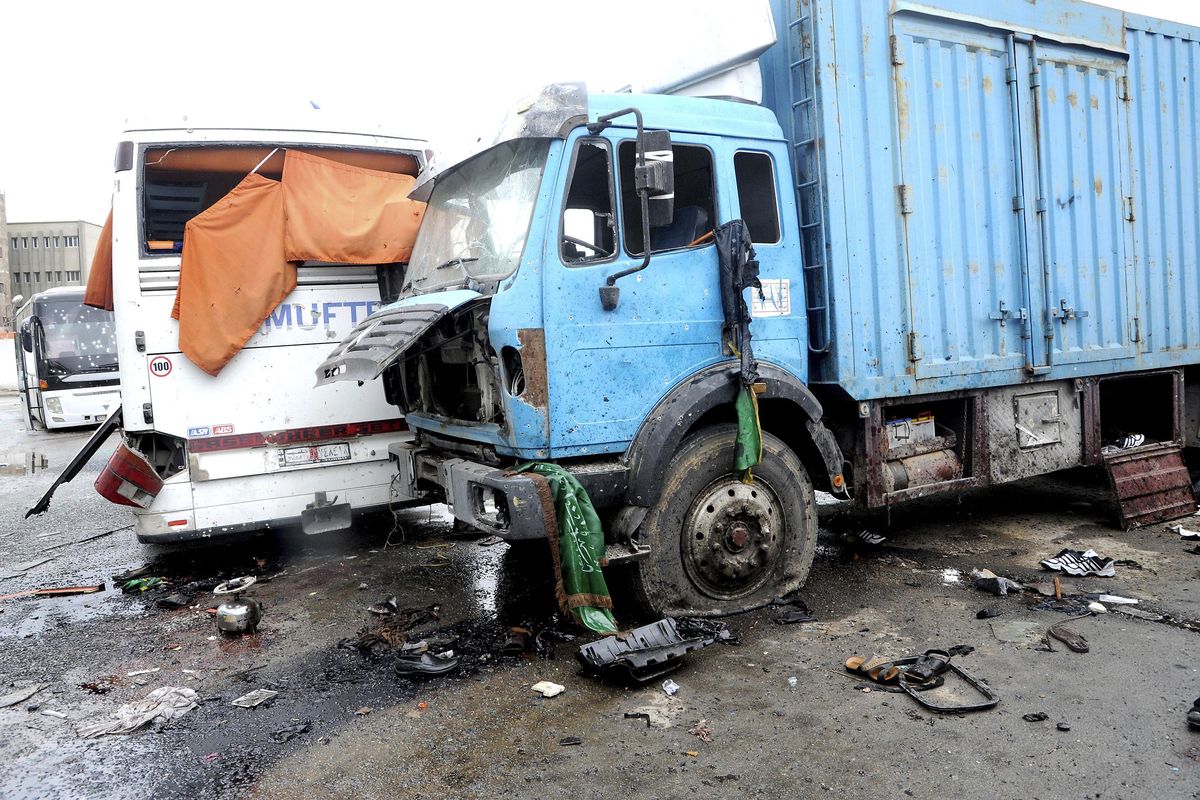 This photo released by the Syrian official news agency SANA shows blood soaked streets and several damaged buses in a parking lot at the site of an attack by twin explosions in Damascus, Syria, Saturday. Twin explosions Saturday near religious shrines frequented by Shiite pilgrims in the Syrian capital Damascus killed dozens of people, Arab media and activists report. (Uncredited / SANA via Associated Press)