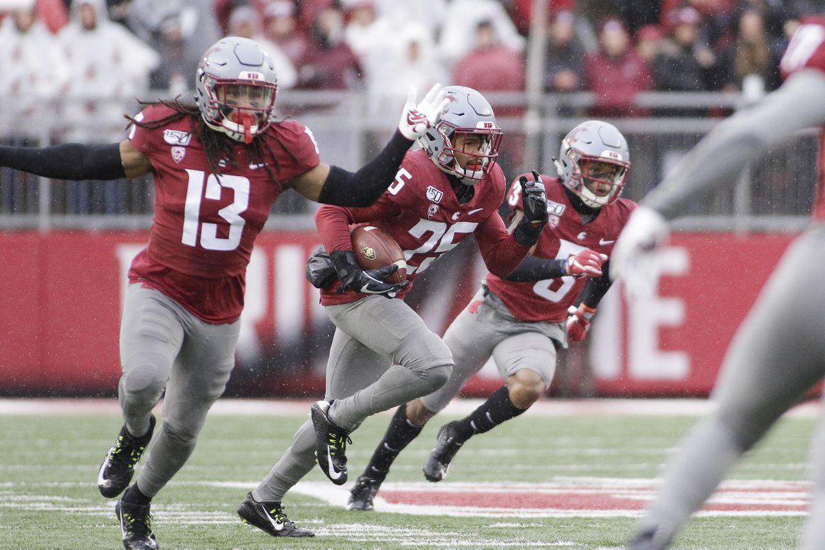 Washington State safety Skyler Thomas, center, runs with a Colorado pass he intercepted while flanked by teammates Jahad Woods, left, and Daniel Isom during the first half of an NCAA college football game in Pullman, Wash., Saturday, Oct. 19, 2019. (Young Kwak / AP)