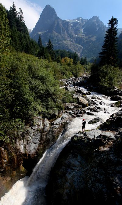 Tokaloo Rock stands September 2012 as a man looks at waterfalls created by the Puyallup River near North Puyallup Camp at Mount Rainier National Park in Washington state. (Drew Perine / (Tacoma) News Tribune)