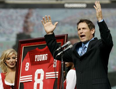 Steve Young gestures to fans as his No. 8 is retired during a halftime ceremony in San Francisco. (Associated Press / The Spokesman-Review)