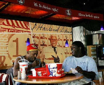 
Two customers enjoy a light moment as they share a bucket of KFC chicken at a Louisville, Ky., restaurant. 
 (Associated Press / The Spokesman-Review)
