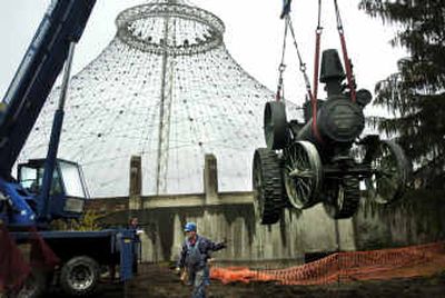 
Darrell Gunning holds onto an antique steam tractor being lifted by a crane from a hole next to the Pavilion basement in Riverfront Park on Tuesday. 
 (Holly Pickett / The Spokesman-Review)