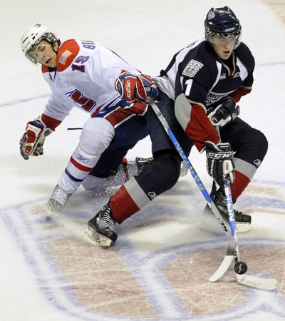 Spokane Chiefs Jared Spurgeon (18)and Tri-City  Americans Kruise Reddick (11) compete for control of the puck in the second period Friday night in the Spokane Arena Friday. (Colin Mulvany / The Spokesman-Review)