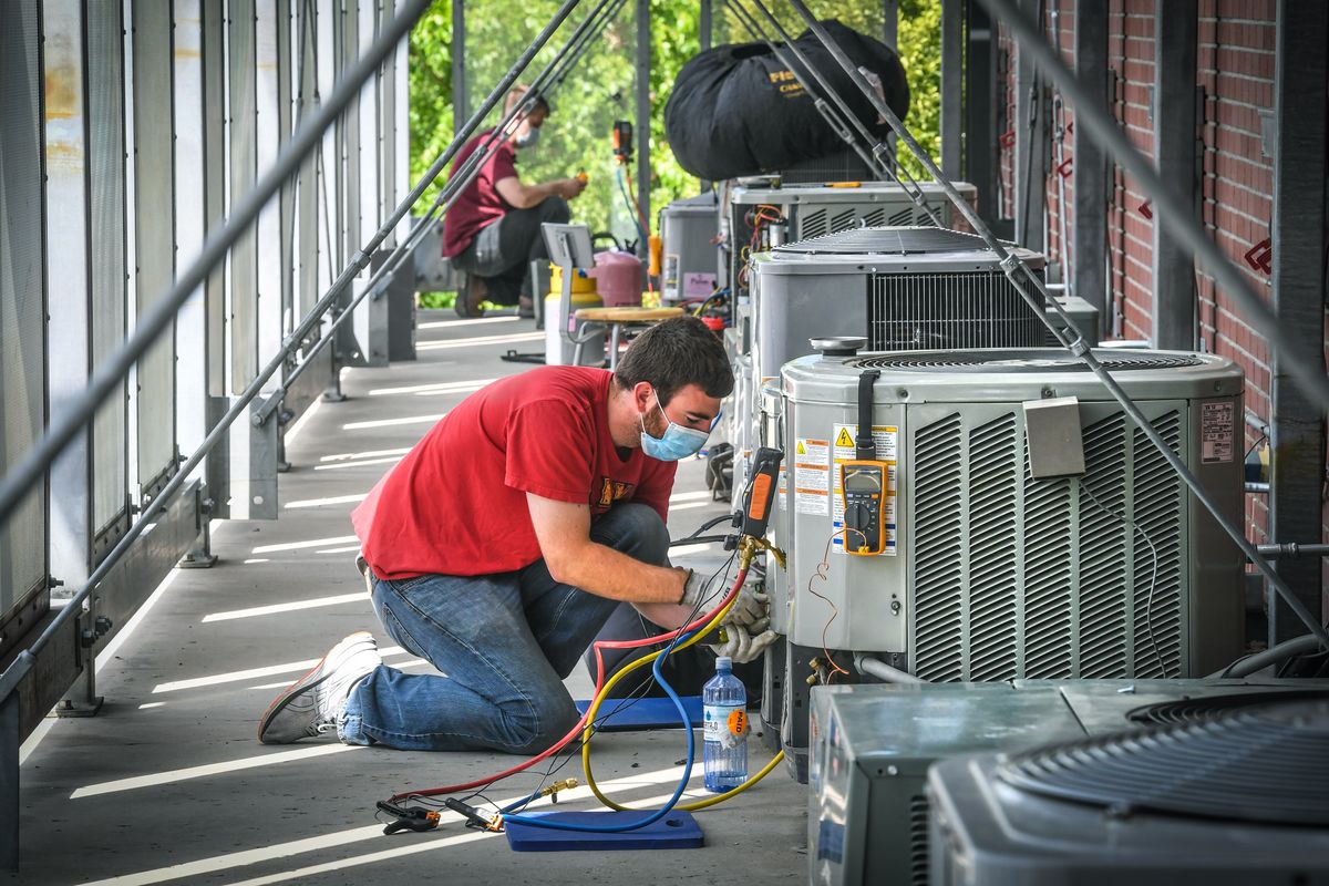 Spokane Community College student Tyler Rice performs a check on an air conditioning unit during class on Thursday.  (Dan Pelle / The Spokesman-Review)