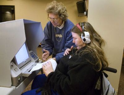 
Adonna Yuse with the Spokane County Elections Office demonstrates to Jan Richards how the AutoMARK voting machine works at Eastern Washington University on Monday.  Spokane County has 15 new machines that read ballots out loud to users wearing  headphones,  allowing people with various disabilities  to vote using a touch screen. 
 (Colin Mulvany / The Spokesman-Review)