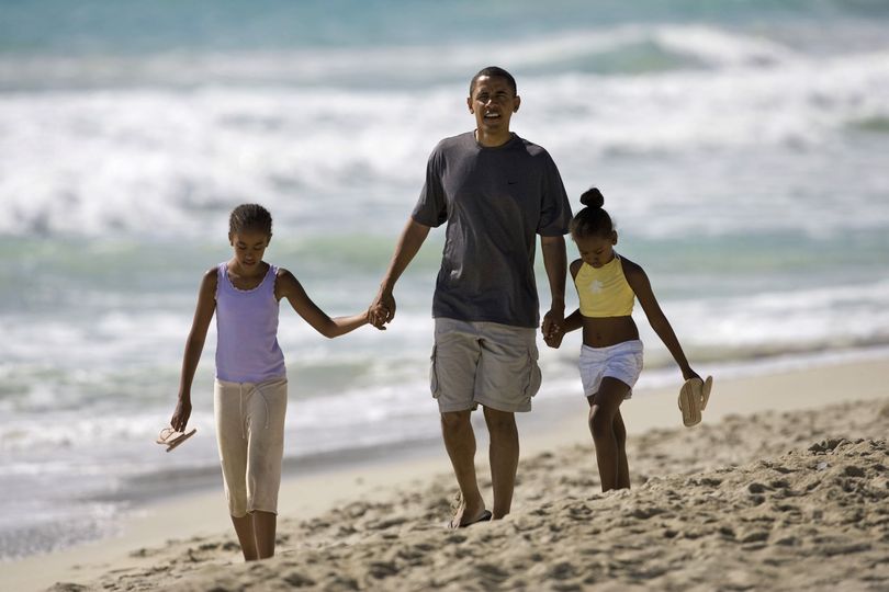 ORG XMIT: WX103 FILE -- In this Aug. 12, 2008 file photo, then Democratic presidential candidate Sen. Barack Obama, D-Ill. walks down Kailua Beach in Kailua, Hawaii, with his daughters Malia, 10, left, and Sasha, 7, during their vacation in Hawaii.  (AP Photo/Marco Garcia, File) (Marco Garcia / The Spokesman-Review)