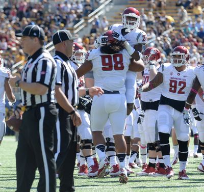 WSU’s Kalafitoni Pole bear hugs Daquawn Brown after the Cougars recovered a fumble near Cal’s goal line.