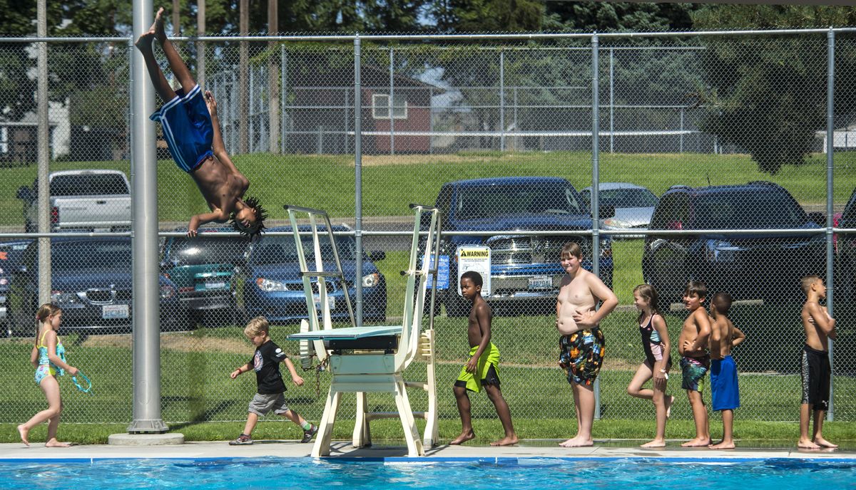 LaVae Cate, 13, springs off the Liberty Park Aquatic Center diving board during Free Swim Week, Aug. 15, 2017. Liberty pool will open June 18. Only Witter Aquatic Center in Mission Park will open May 7. (Dan Pelle / The Spokesman-Review)