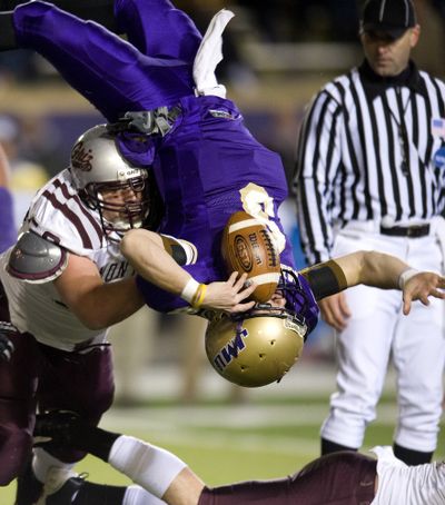James Madison quarterback Drew Dudzik is upended by a Montana defender during the first quarter. (Associated Press / The Spokesman-Review)