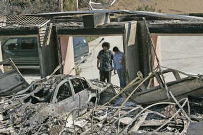
Robert Zarrella and his sister, Kate, look over the burnt ruins of their home in Poway, Calif., on Wednesday.Associated Press
 (Associated Press / The Spokesman-Review)