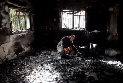 
A Palestinian man examines the damage to the home of  security force officer Col. Mohammed Ghayeb that was attacked Thursday during fighting between forces loyal to Fatah and Hamas.
 (Associated Press / The Spokesman-Review)