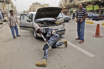 A Sunni Awakening Council member searches a vehicle at a checkpoint in north Baghdad’s Azamiyah neighborhood on Sunday.   (Associated Press / The Spokesman-Review)