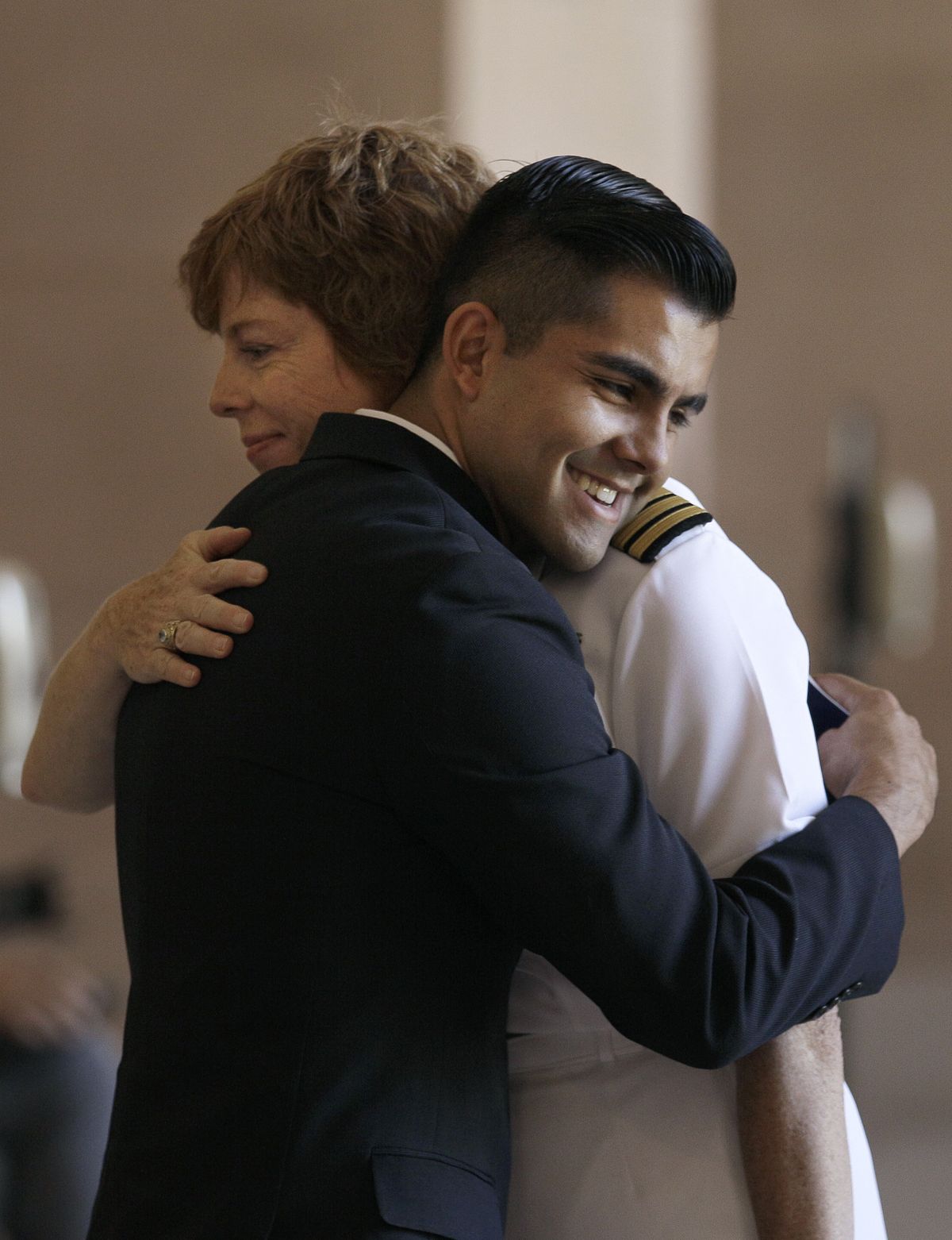 Retired U.S. Navy Petty Officer Joseph Rocha, foreground, hugs retired Navy Cmdr. Zoe Dunning before a news conference in San Francisco on Tuesday. (Associated Press)