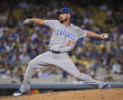This Oct. 19, 2016 file photo shows Chicago Cubs relief pitcher Travis Wood throwing during the seventh inning of Game 4 of the National League baseball championship series against the Los Angeles Dodgers in Los Angeles. A person familiar with the deal says the Kansas City Royals and left-hander Travis Wood have agreed to a $12 million, two-year contract. (Mark J. Terrill / Associated Press)