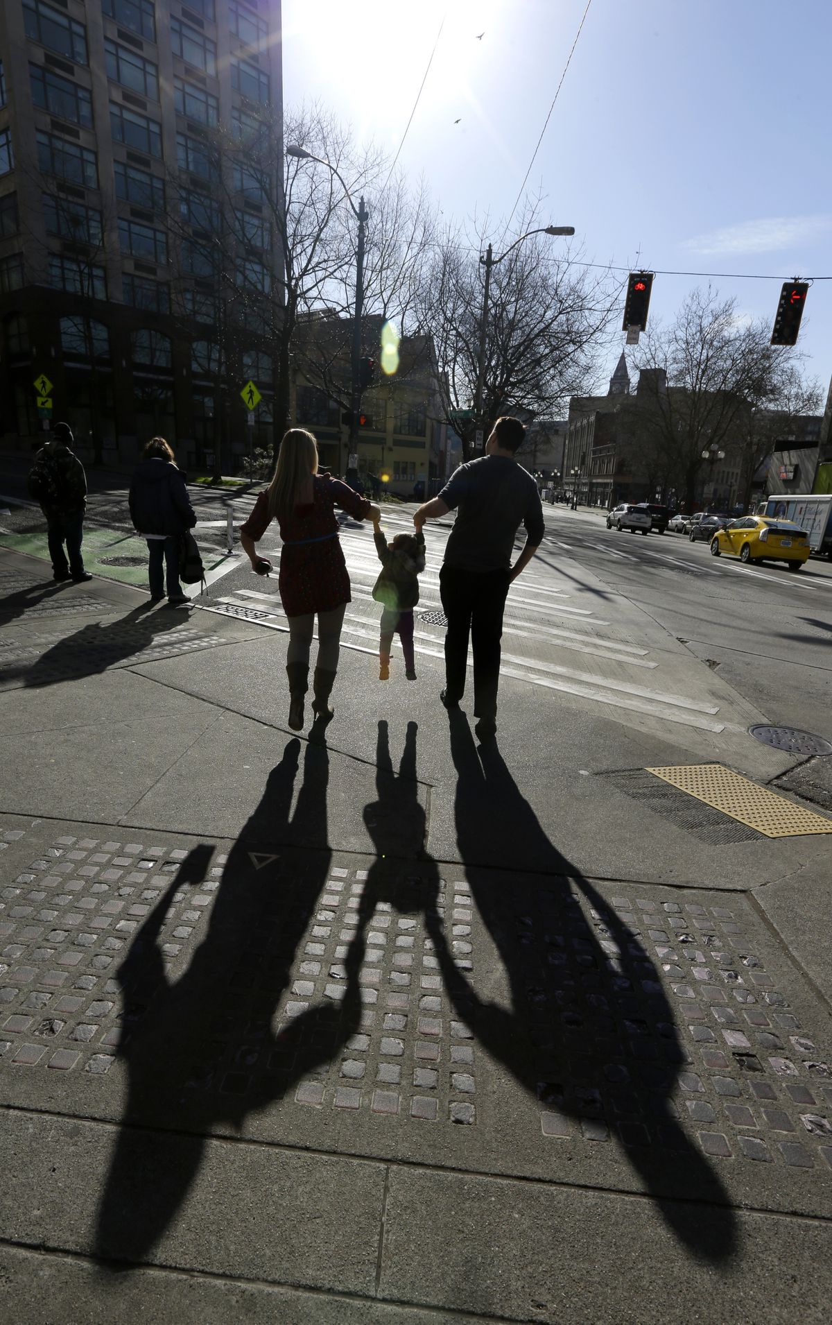 Jenny Kelly and her husband, Michael, walk with their daughter, Elea, 2, near their loft apartment in downtown Seattle on March 3. Schools, parks and other amenities are keeping the family downtown. (Associated Press)