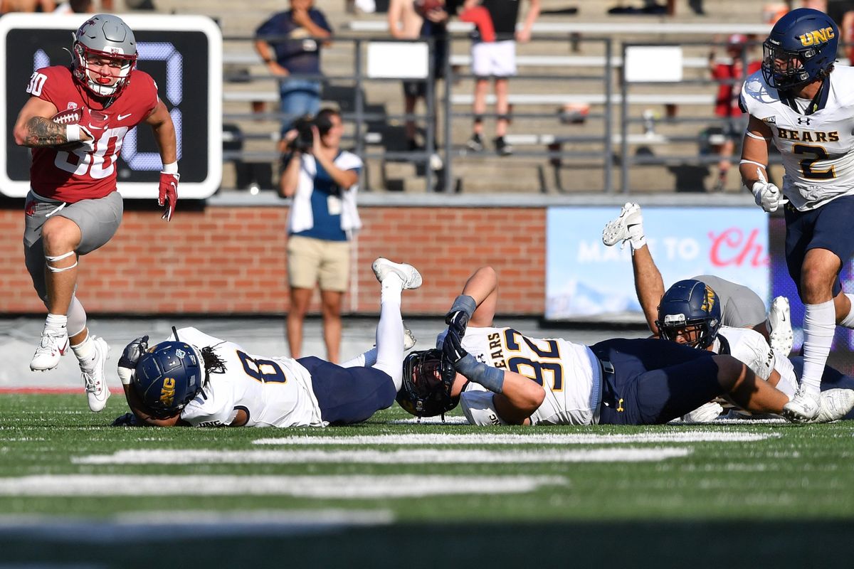 Washington State running back Dylan Paine evades Northern Colorado’s Tizell Lewis (8) and Nick Norris (92), both on the ground, during the second half Saturday in Pullman.  (Tyler Tjomsland/The Spokesman-Review)